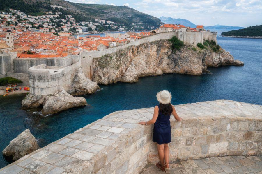 A woman in a navy dress fcacing away from the camera and admiring the vies on her Dubrovnik weekend getaway