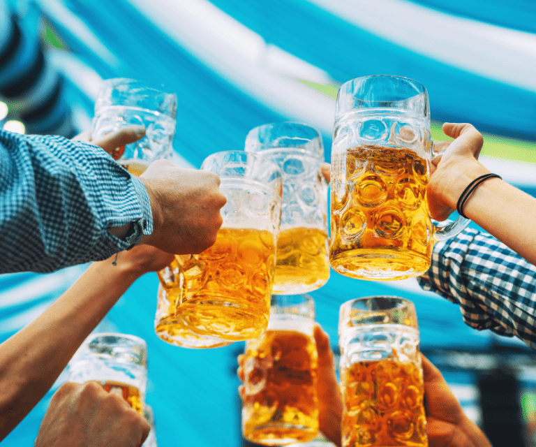 Seven friends clink dimpled mugs of beer during their weekend break to Germany