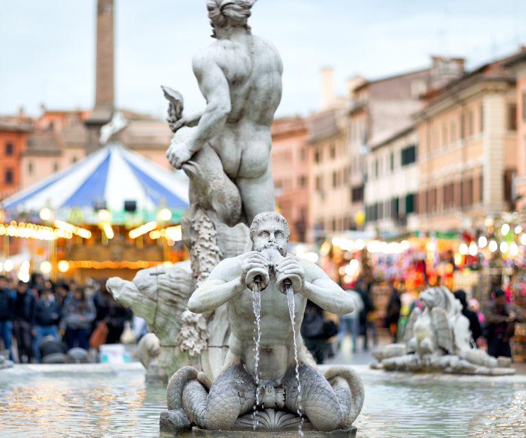 A photo of the fountain del moro at Piazza Navona, on the background you can see the lights of one of Rome's Christmas markets