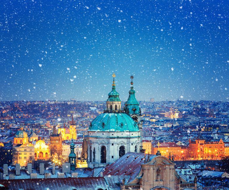 Snowfall over the cathedrlal of Saint Nicholas, a must-see sight during your Christmas getaway to Prague
