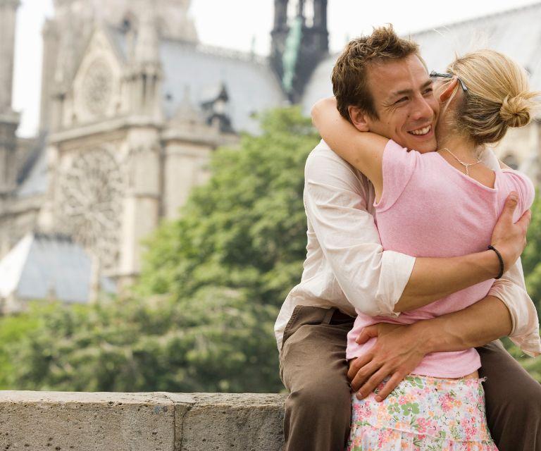 A couple embracing each other near the Notre Dame, a must-see sight on a romantic getaway to Paris