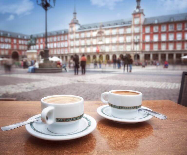 To cups of coffee on a table in a cafe on Plaza Mayor, a must-visit place during a weekend break to Madrid