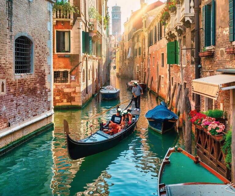 Stunning views of black gondolas narrow canals surrounded by beautiful houses, a must-see sight on a city break to Venice