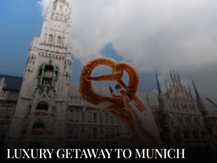 Someone is holding a traditional pretzel in front of Marienplatz, a must-see sight during a luxury getaway to Munich