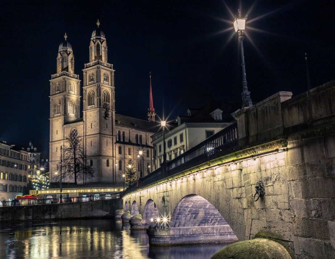 Grossmunster in Zurich from the Limmat at night, a must-visit place on a Chrismas getaway to Zurich